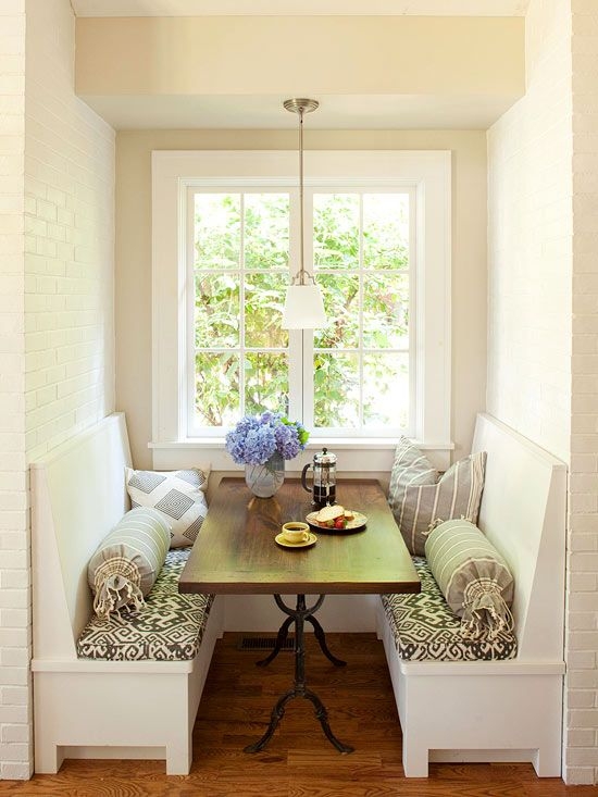 Banquette Dining Set with Tasseled Bolsters and Geometric Cushions.