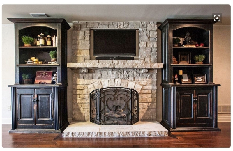 Distressed Black Symmetrical Built-In Bookcases Flanking Stone Fireplace