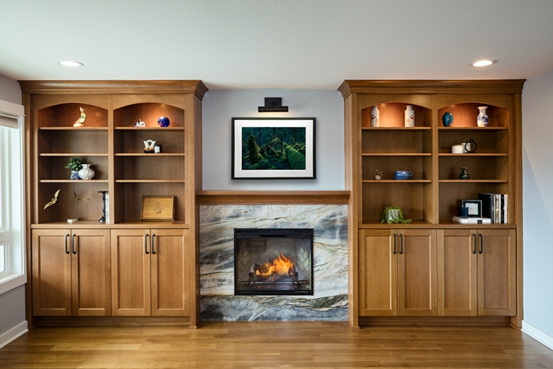 Golden Oak Arched Built-In Bookcases with Veined Stone Fireplace Surround