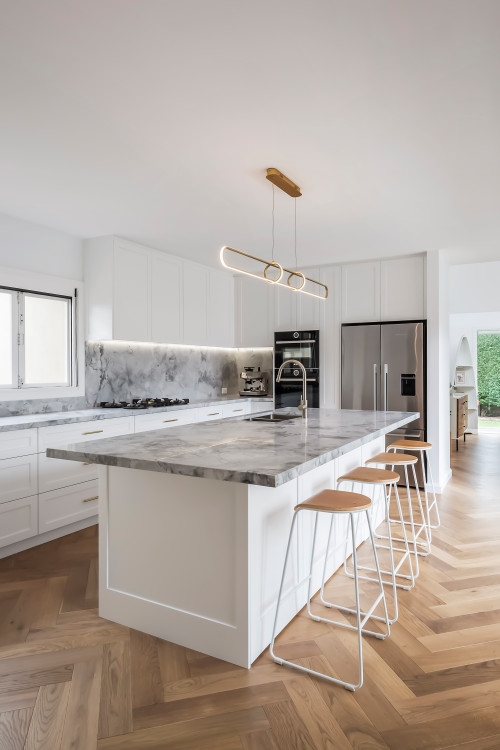 Large Kitchen Island With Veined Stone And Herringbone Floor