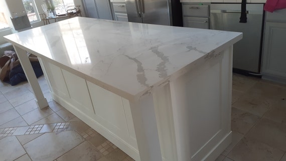 Large White Kitchen Island With Shaker Paneling And Seating Overhang