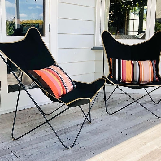 Matte Black Butterfly Chair with Contrast Piping and Striped Pillow