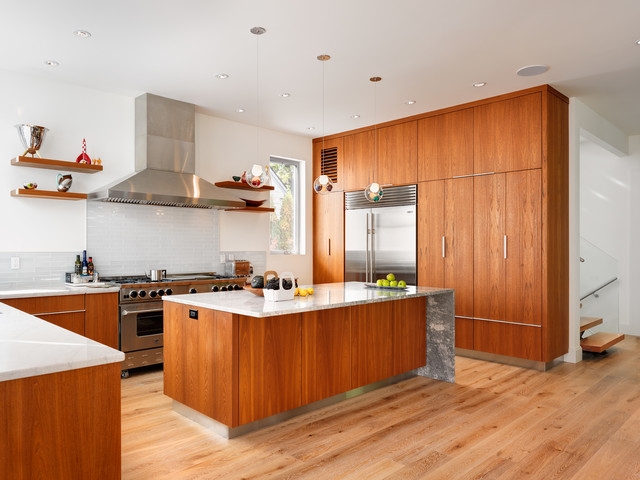 Modern Kitchen Cabinetry with Vertical Grain and Waterfall Stone Island