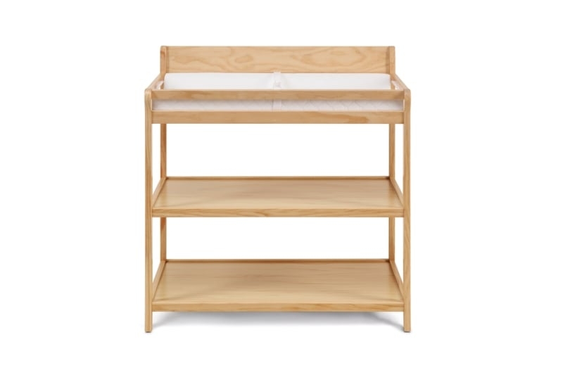 Natural wood changing table with three tier open shelving and pad