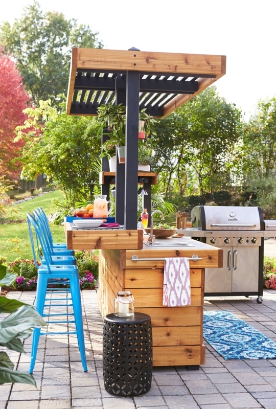 Outdoor Kitchen Island with Blue Bar Stools and Slatted Pergola Roof