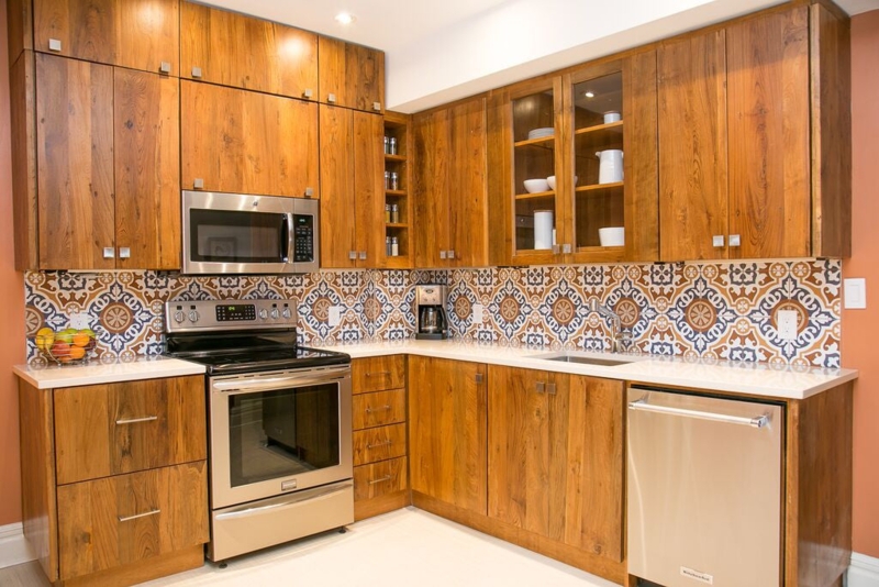 Reclaimed Teak Kitchen Cabinets with Glass Fronts and Patterned Tile