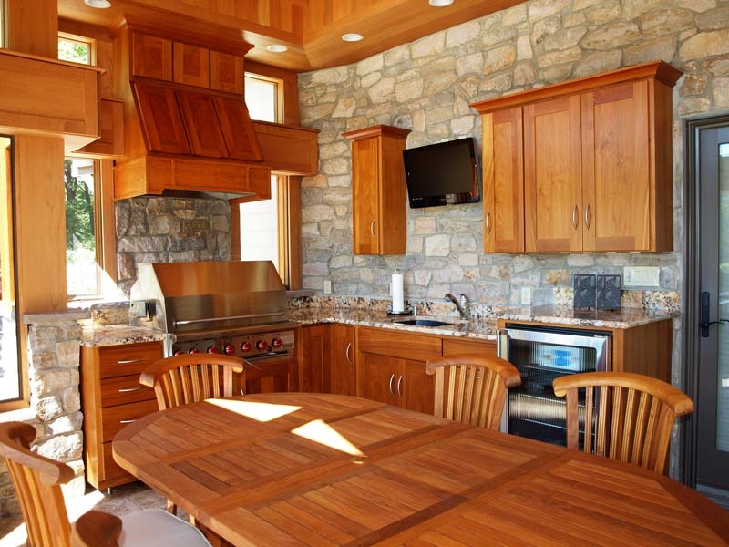 Rustic Outdoor Kitchen with Masonry Wall and Integrated Grill Wood Hood