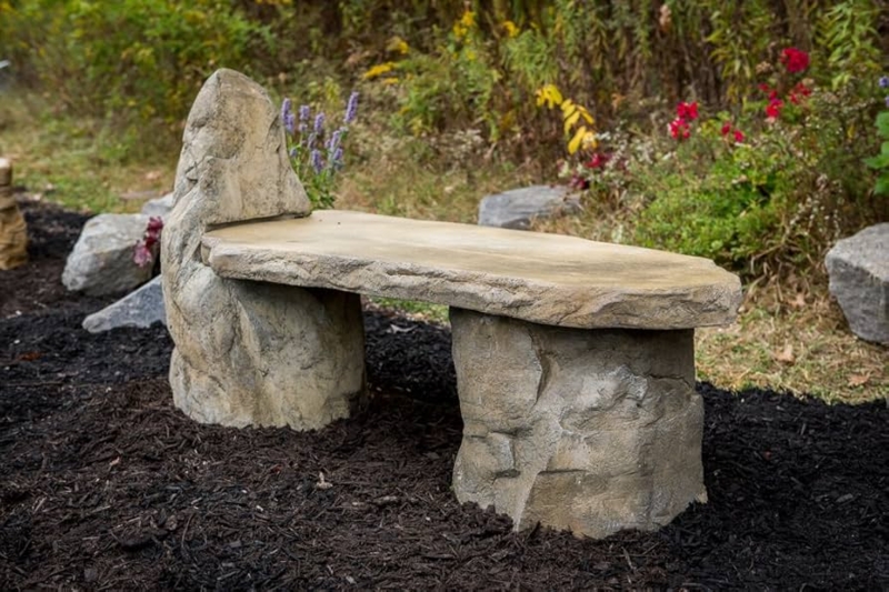 Rustic Stone Garden Bench: Boulder Legs, Slab Seat, Weathered Finish.