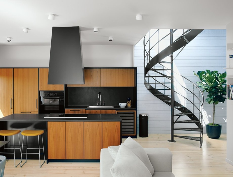 Teak Kitchen Cabinets with Matte Black Hood and Spiral Staircase