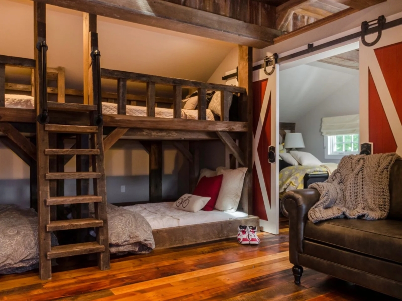 Timber Frame Bunk Room with Sliding Barn Door and Industrial Rails
