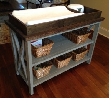 Two-tone nursery storage changing table with X-frame sides and baskets
