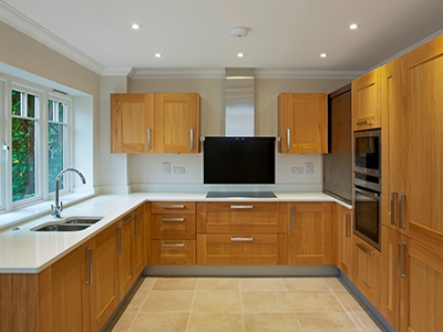 U-Shaped Kitchen Cabinetry with White Stone Countertops