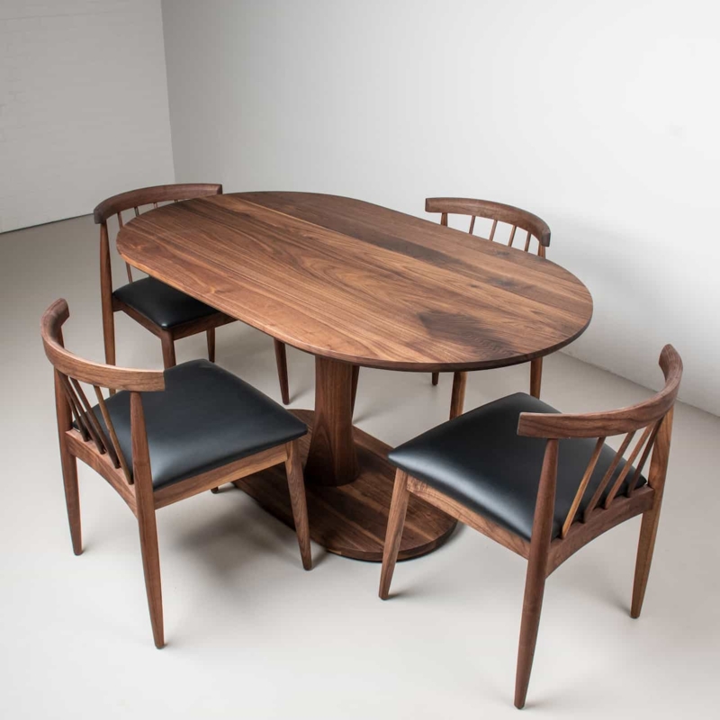 Walnut Pedestal Dining Set with Oval Top and Black Leather-Like Seats