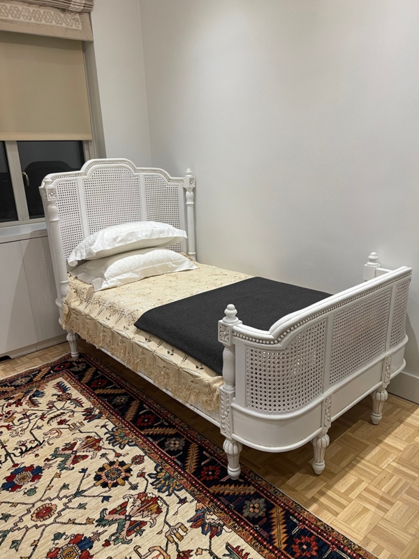 Ornate White Twin Bed with Woven Cane Panels and Carved Finials.