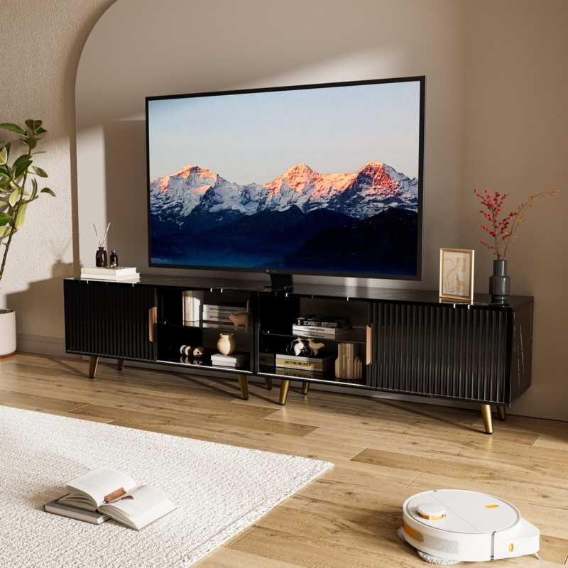 Black ribbed TV stand with gold tapered legs and glass.