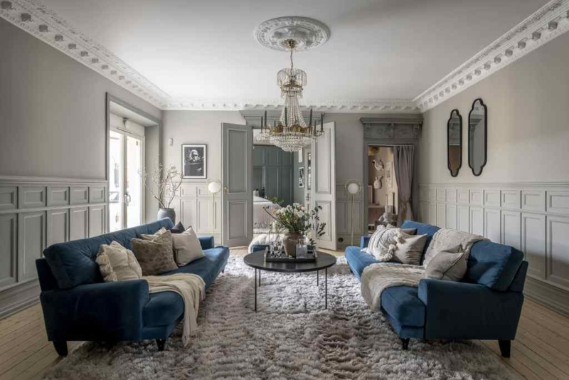 Navy Blue Velvet Sofas in Symmetrical Room Layout with Grey Wainscoting