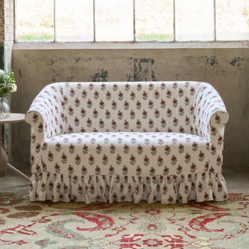 Slipcovered Floral Loveseat with Ruffled Skirt and Curved Silhouette
