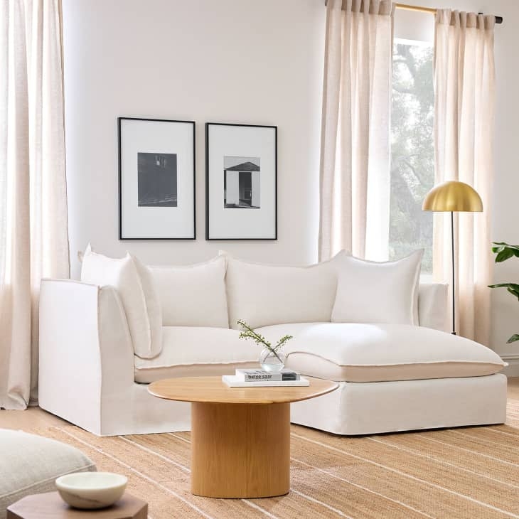 White Slipcovered Sectional Sofa with Round Wood Pedestal Table