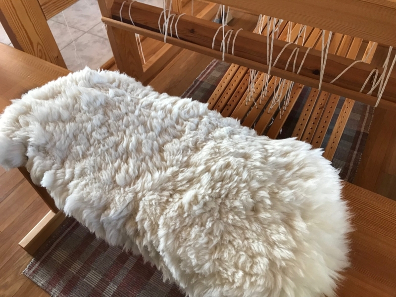 Shaggy Sheepskin Bench Cover Over Wooden Loom Bench