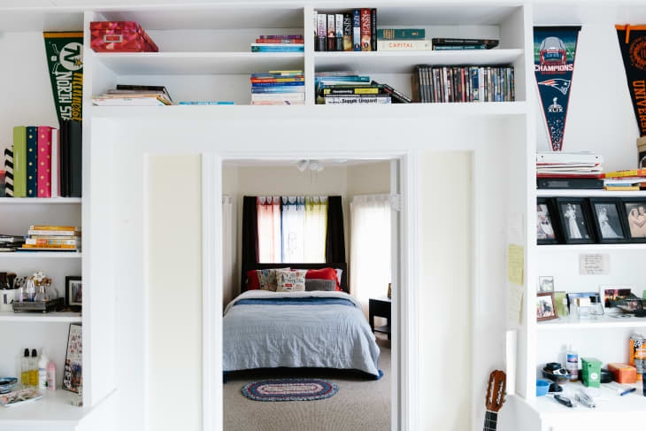 Floor to Ceiling Built In Shelving White against Navy Accent Wall