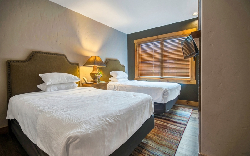 Lodge Bedroom Exposed Log Walls Beamed Ceiling Upholstered Beds
