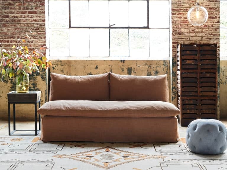 Armless Sofa with Plush Back Cushions and Relaxed Slipcover Hem