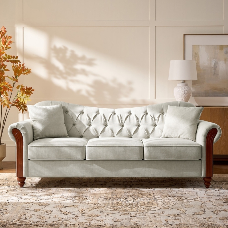 Elegant Cream Tufted Sofa with flared arms and tapered wood legs.