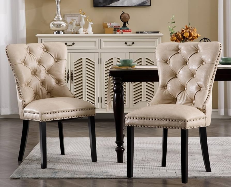 Beige Leather-Like Dining Chairs with Bronze Nailhead Trim and Tufting