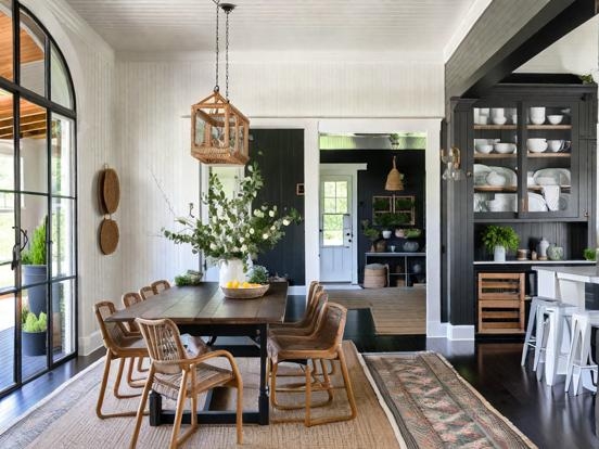 Dining Table against Moody Black Paneled Walls with Arched Floor Mirror