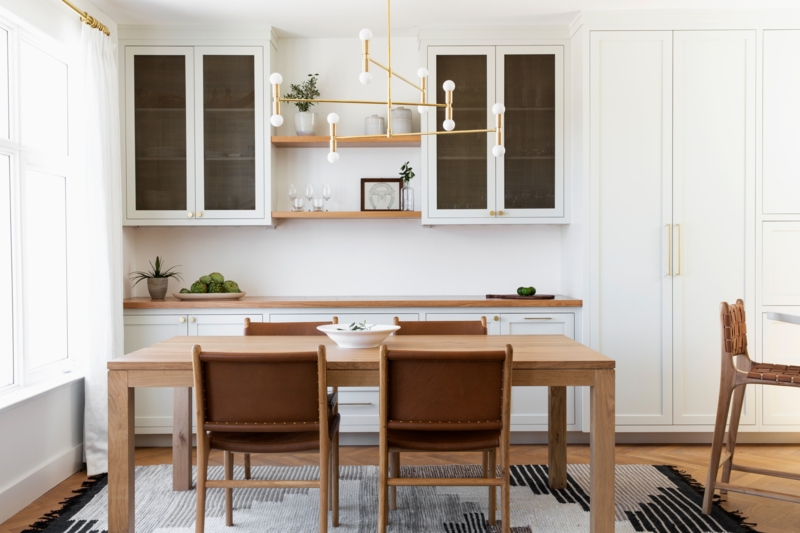 Dining Table: Natural Wood, Mismatched Chairs, White Brick Wall backdrop