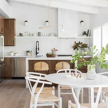 White Wishbone Dining Chairs with Woven Seats near Tulip Pedestal Table.
