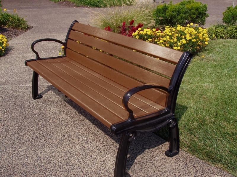 Traditional Outdoor Bench. Dark green resin slats, ornate cast metal arms.