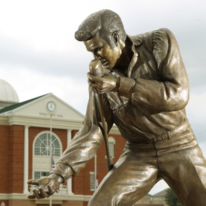 Bronze Outdoor Statue with Dynamic Pose and Guitar Detail.