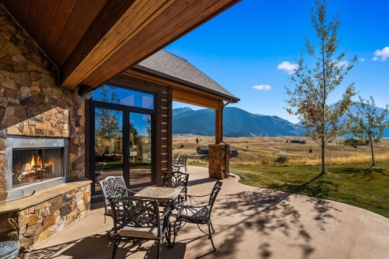 Cabin Living Room with Floor-to-Ceiling Stone Fireplace and Exposed Log Walls