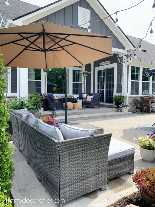 Coastal L-Shaped Outdoor Sectional with Navy Accents & Patterned Rug