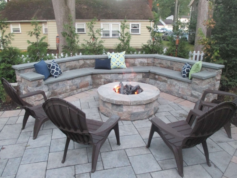 Contemporary Stone Clad Outdoor Fireplace with Dark Wood Pergola