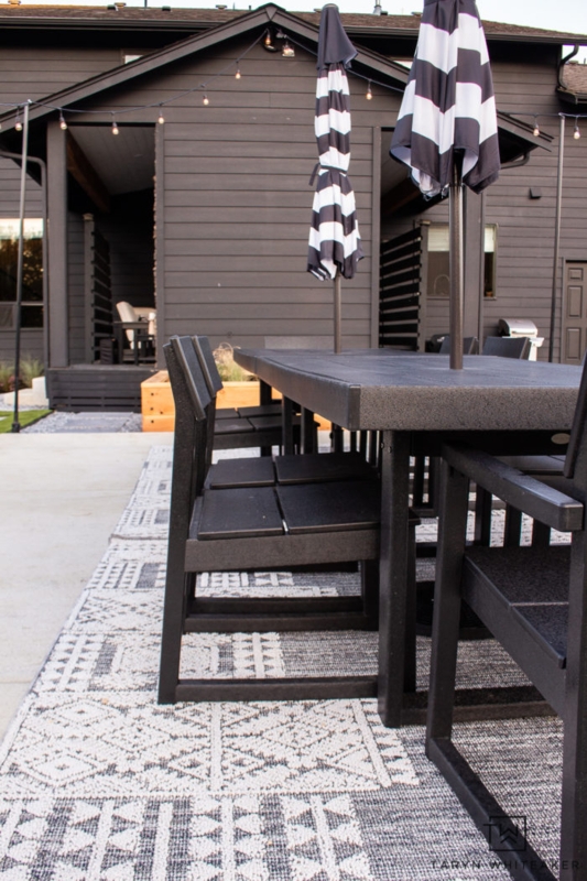 Dining Table with Thick Stone-Like Top and Black Woven Chairs on Modern Patio