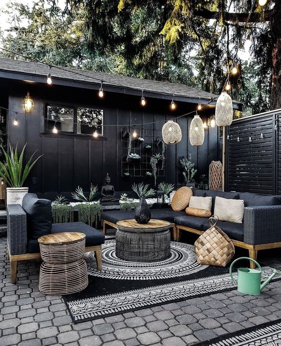 Dramatic Black Wicker Outdoor Sectional with Woven Pendant Lamps