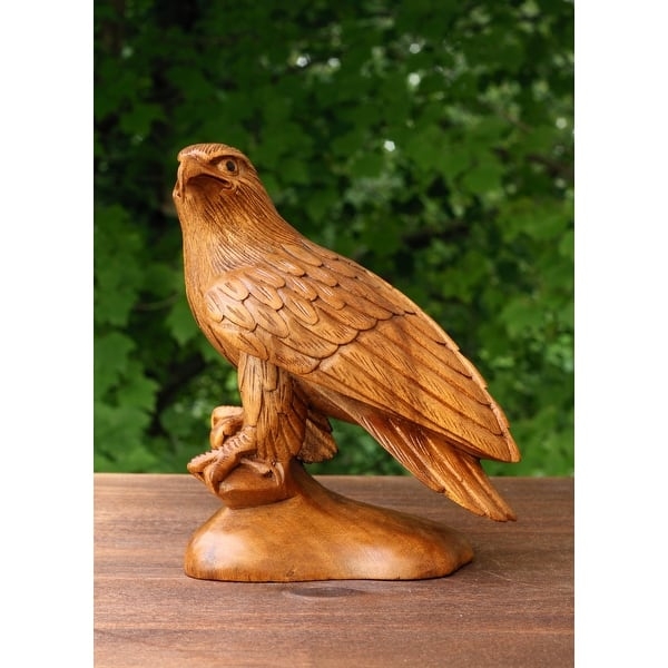 Eagle Statue perched on a branch with a hand carved appearance.