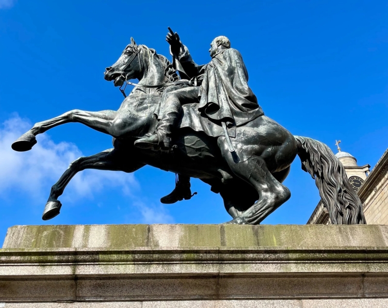 Historical Equine Monument on Ornate Stone Pedestal in Urban Square