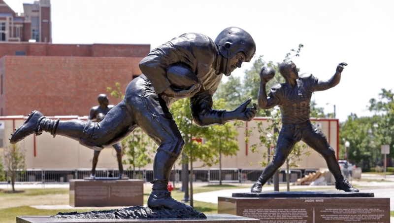 Large Bronze Football Player Statue in Action Pose on Plaza