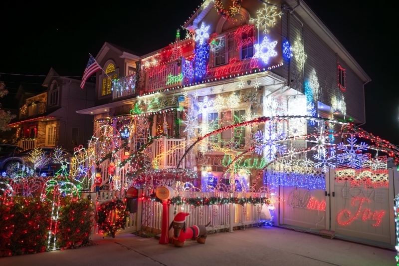 Maximalist Outdoor Holiday Light Display with "Peace on Earth" Sign