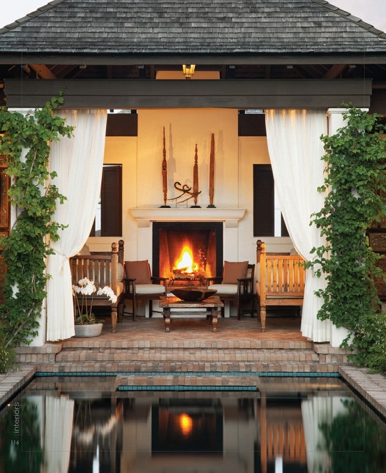 Outdoor Fireplace Stone Masonry Dark Woven Armchairs Wood Ceiling