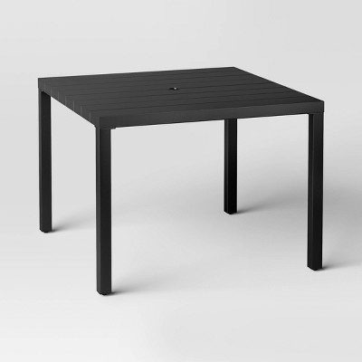 Patio Dining Table featuring Wood-Toned Slat Top and Tapered Metal Legs