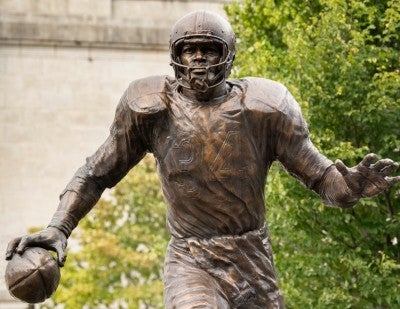 Running Football Player Statue at Modern Stadium Exterior