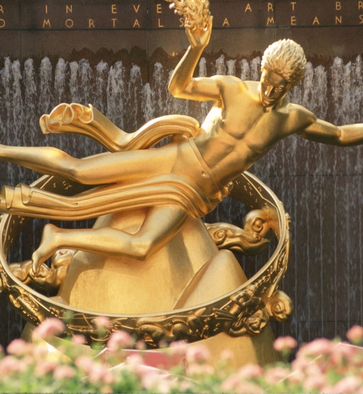 Sculpture of Reclining Bronze Figure set against Geometric Stone Wall