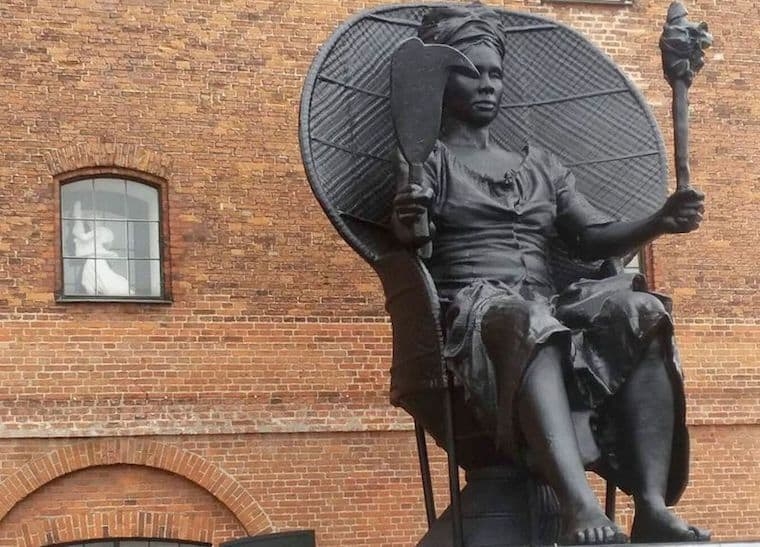 Statue: Matte Black Peacock Chair Silhouette on Coral Stone Base.