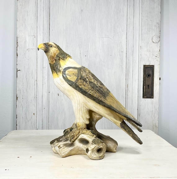 Statue with hawk silhouette, spread wings, and molded plumage detail.