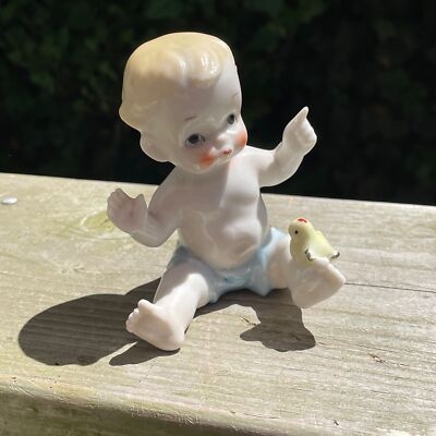 Vintage Porcelain Baby Figurine with Bird on Foot and Floral Accents