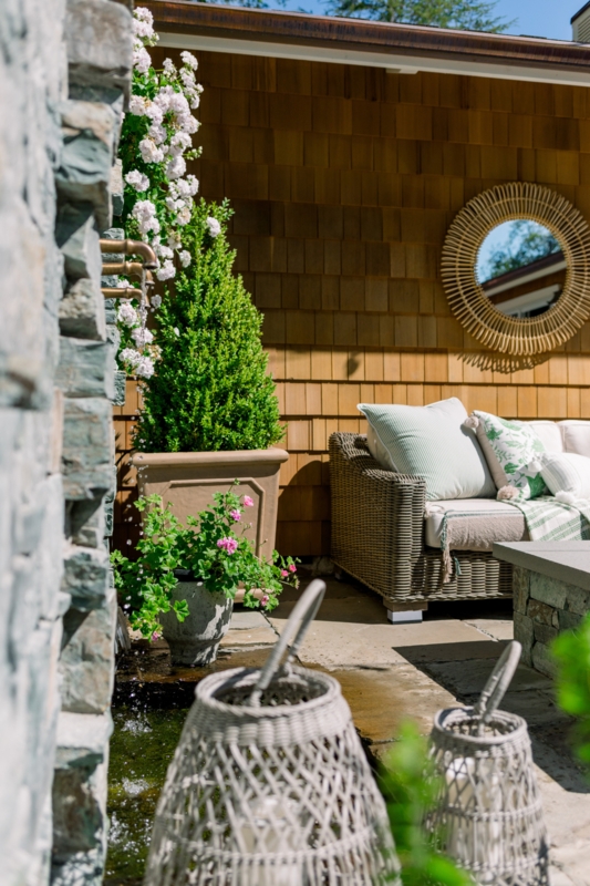 Wicker Patio Seating with Green and White Decor and Layered Textiles